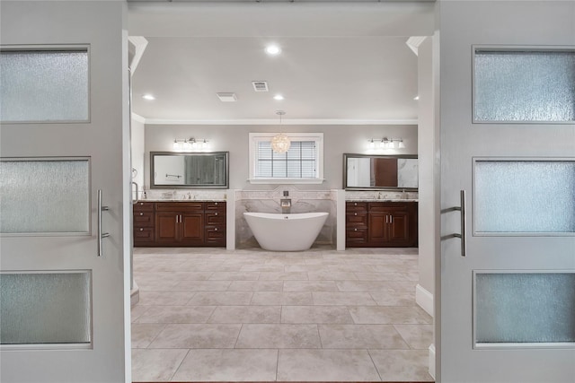 3327 Palm St, Houston, TX 77004 - full bath featuring crown molding, two vanities, a soaking tub, tile patterned flooring, and recessed lighting