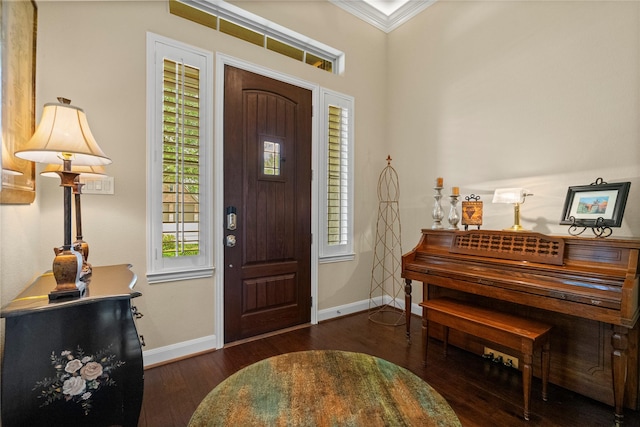foyer entrance featuring plenty of natural light, baseboards, ornamental molding, and wood finished floors