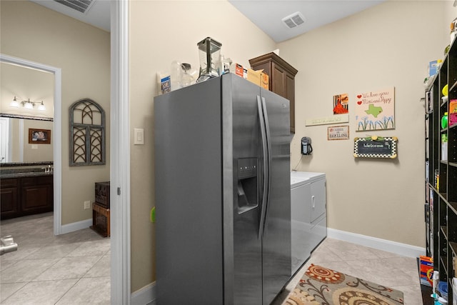 laundry room with independent washer and dryer, visible vents, cabinet space, light tile patterned floors, and baseboards