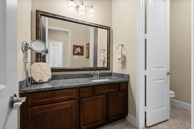 bathroom with toilet, baseboards, tile patterned flooring, and vanity