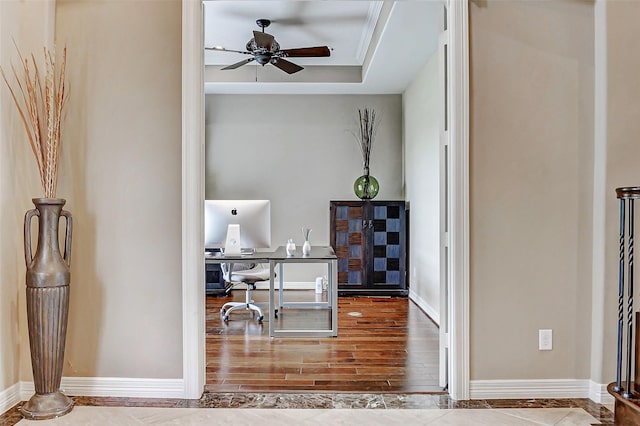 home office with a ceiling fan, wood finished floors, and baseboards