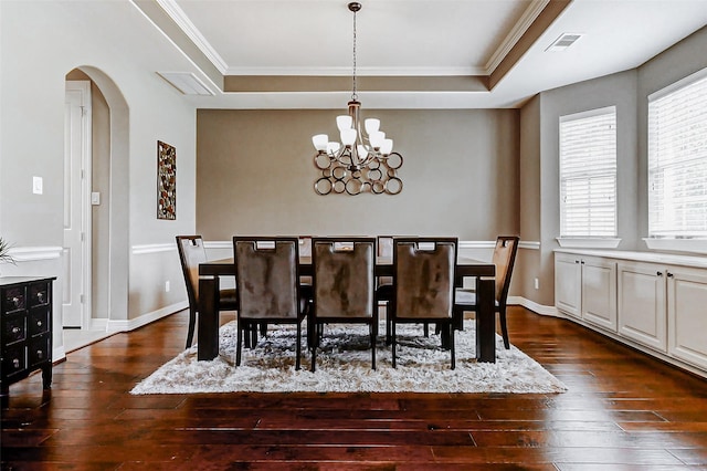 dining space featuring a chandelier, visible vents, dark wood-style floors, and arched walkways