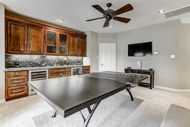 recreation room with light colored carpet, visible vents, wine cooler, and baseboards
