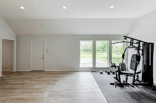 exercise room with recessed lighting, light wood-style flooring, lofted ceiling, and baseboards