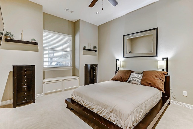 carpeted bedroom featuring a ceiling fan, visible vents, and baseboards