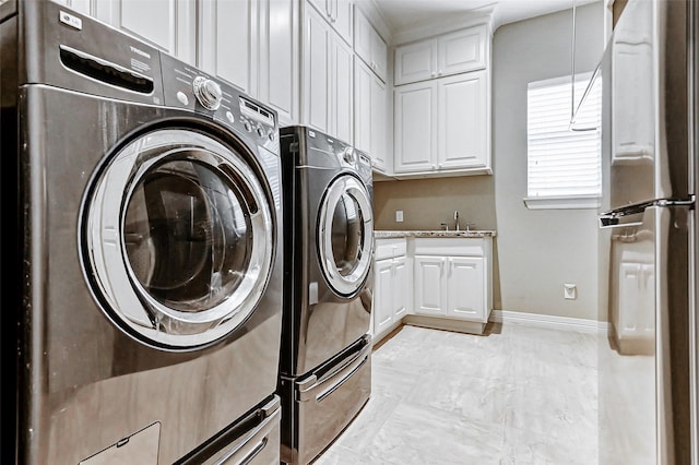 laundry room featuring a sink, cabinet space, independent washer and dryer, marble finish floor, and baseboards