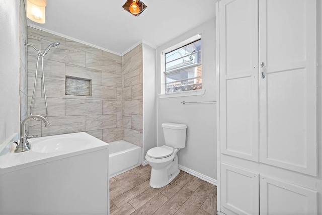 full bath with wood finished floors, toilet, shower / bathing tub combination, a sink, and baseboards