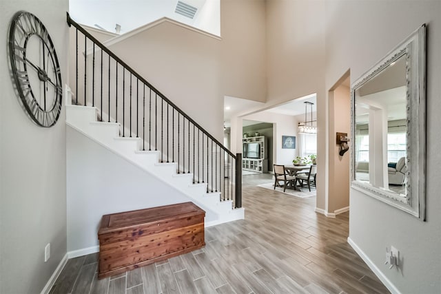 foyer with baseboards, stairway, and wood finished floors