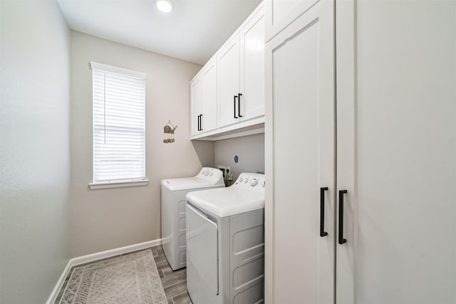 laundry area featuring light wood-style floors, baseboards, cabinet space, and washing machine and dryer