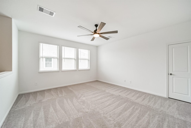 spare room with visible vents, ceiling fan, carpet flooring, and baseboards