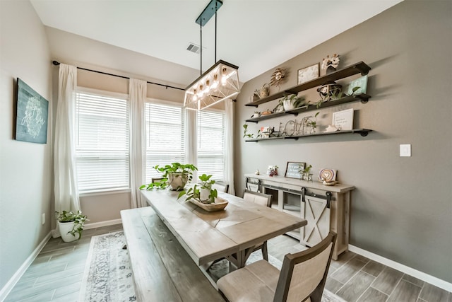 dining area featuring baseboards, visible vents, and wood finish floors