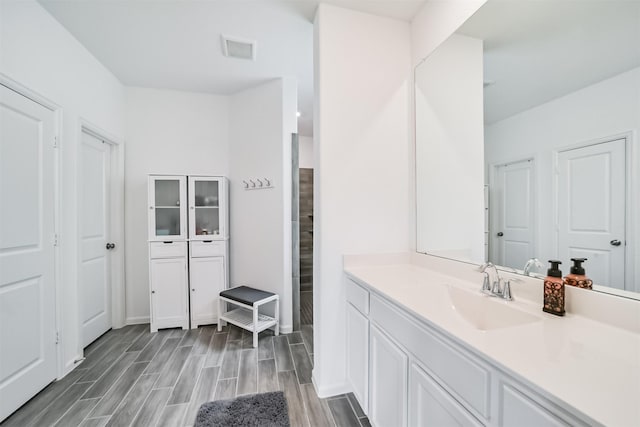 bathroom with wood finished floors, visible vents, and vanity