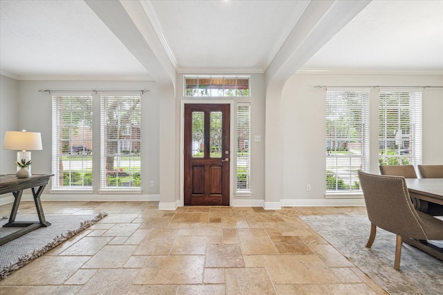 entryway with crown molding, baseboards, and stone tile flooring