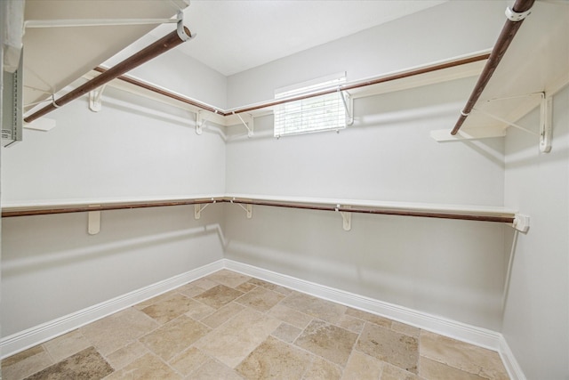walk in closet with stone tile floors