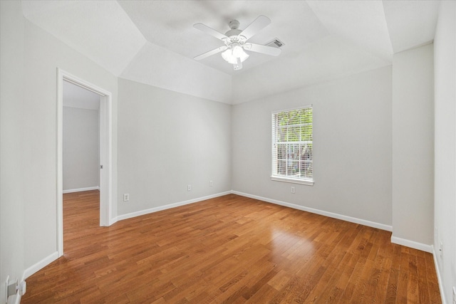 spare room with visible vents, a ceiling fan, light wood finished floors, and baseboards