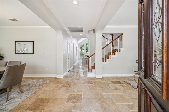 entrance foyer with crown molding, baseboards, stone tile flooring, and visible vents