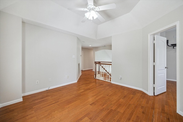 spare room with baseboards, ceiling fan, and wood finished floors