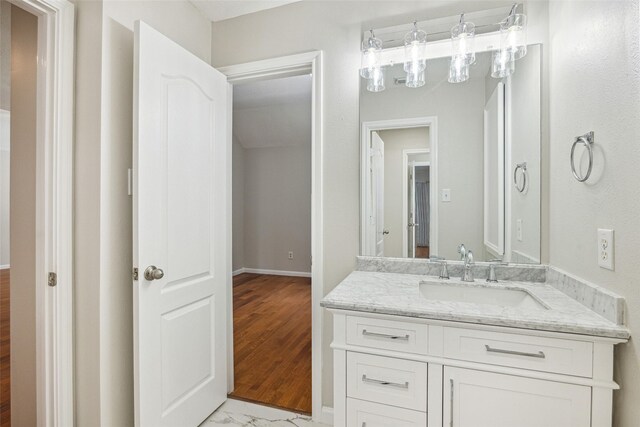 bathroom with baseboards, marble finish floor, and vanity