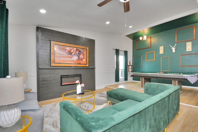 living area featuring recessed lighting, wood finished floors, billiards, and a glass covered fireplace