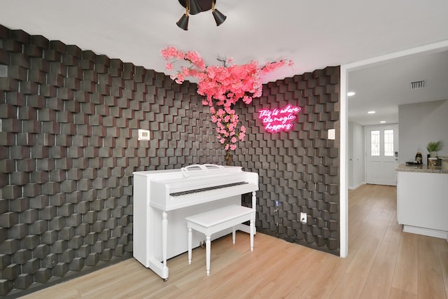 misc room with recessed lighting, wood finished floors, an accent wall, baseboards, and visible vents