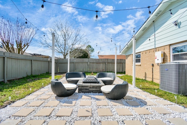 view of patio with cooling unit, a fenced backyard, and an outdoor fire pit