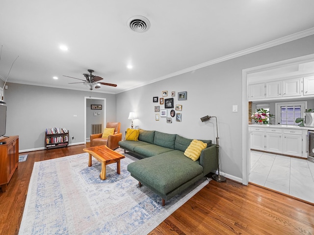 living area featuring visible vents, recessed lighting, ornamental molding, and a ceiling fan