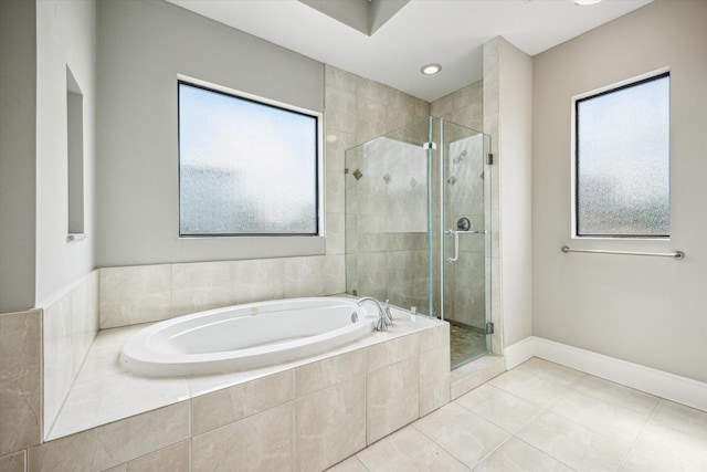bathroom with baseboards, a bath, a stall shower, and tile patterned floors