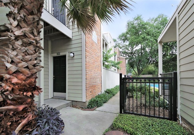 2001 Bering Unit 1K, Houston, TX 77057 - exterior space featuring fence, a balcony, a gate, and brick siding