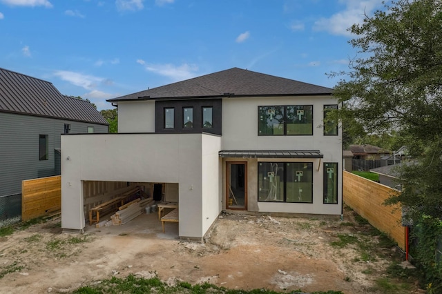7006 Schiller St, Houston, TX 77055 - rear view of property featuring stucco siding, fence, a standing seam roof, metal roof, and a garage