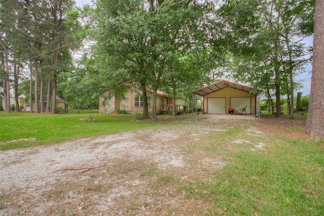 81 Westlake Rd, Trinity, TX 75862 - view of green lawn with an outdoor structure, a detached garage, and driveway