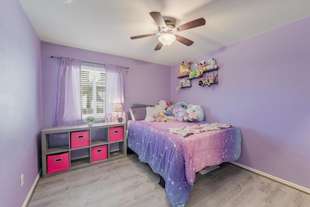 bedroom with ceiling fan, wood finished floors, and baseboards