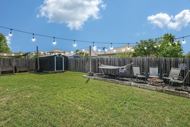 view of yard with an outdoor fire pit, an outdoor structure, a fenced backyard, and a storage shed
