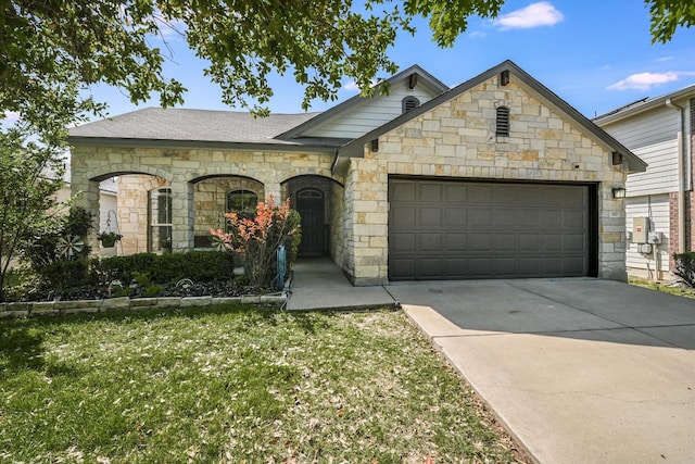 view of front of home featuring a garage, a front lawn, concrete driveway, and stone siding