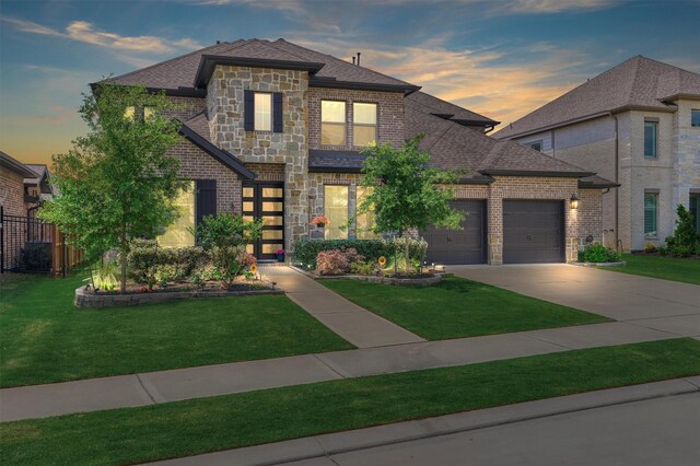 french country inspired facade with stone siding, brick siding, a shingled roof, concrete driveway, and an attached garage