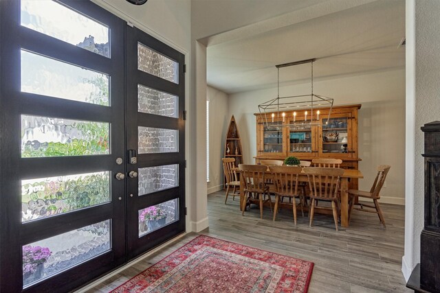 entrance foyer featuring french doors, baseboards, and wood finished floors