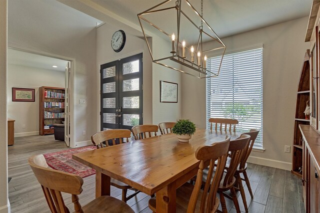 dining room featuring recessed lighting, baseboards, an inviting chandelier, and wood finished floors