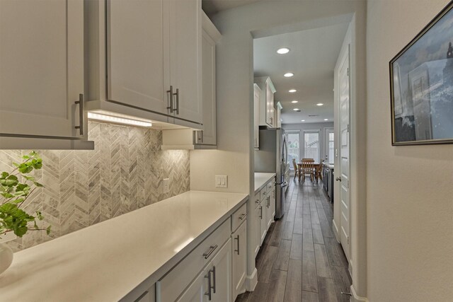 kitchen with white cabinets, light countertops, recessed lighting, decorative backsplash, and dark wood-style floors