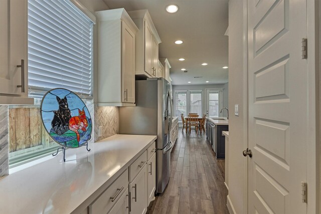 kitchen featuring dark wood-style flooring, recessed lighting, light countertops, white cabinets, and tasteful backsplash