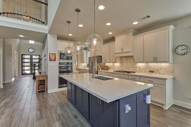 kitchen featuring white cabinets, stainless steel appliances, visible vents, and a sink