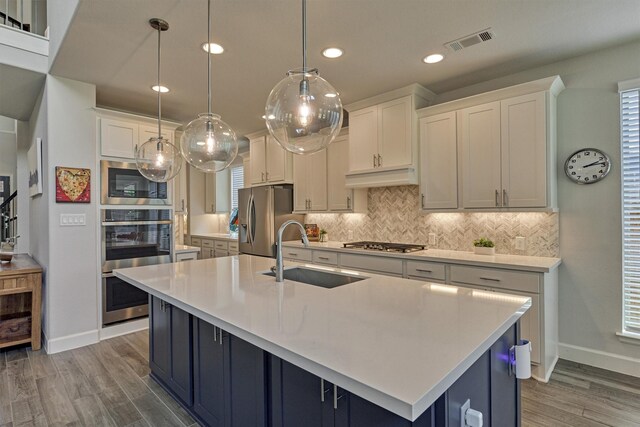 kitchen featuring light countertops, stainless steel appliances, visible vents, and a sink