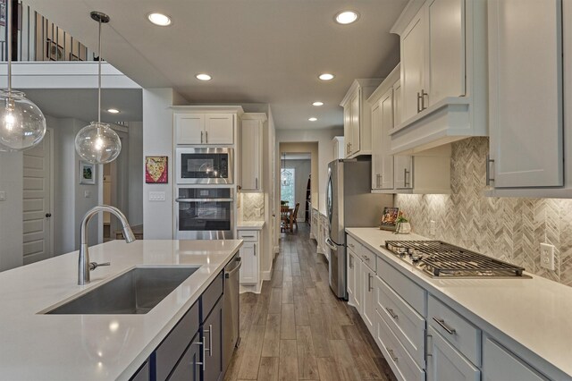 kitchen featuring light countertops, recessed lighting, appliances with stainless steel finishes, and a sink
