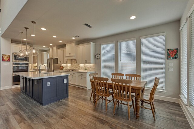 kitchen featuring a wealth of natural light, white cabinets, and visible vents