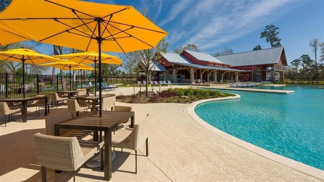community pool with fence and a patio area