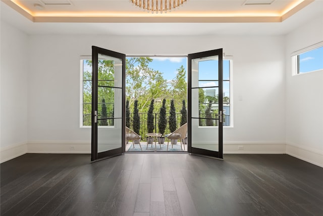 entryway with baseboards, a raised ceiling, and wood finished floors