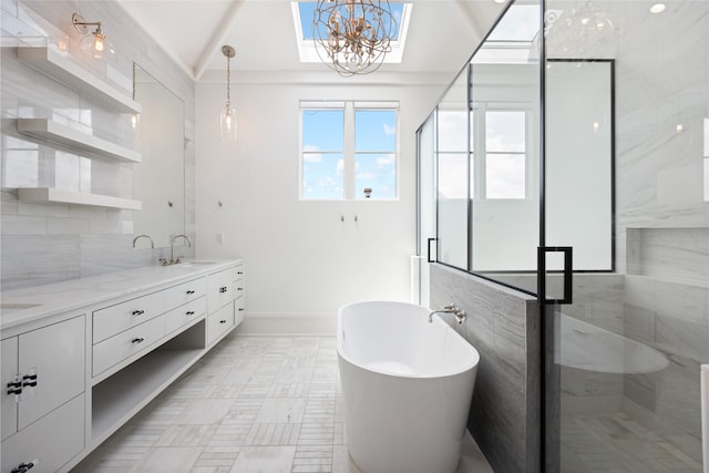 full bathroom featuring a freestanding bath, a sink, double vanity, a chandelier, and a shower stall