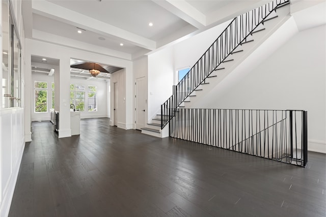 entrance foyer with baseboards, beamed ceiling, recessed lighting, and wood finished floors