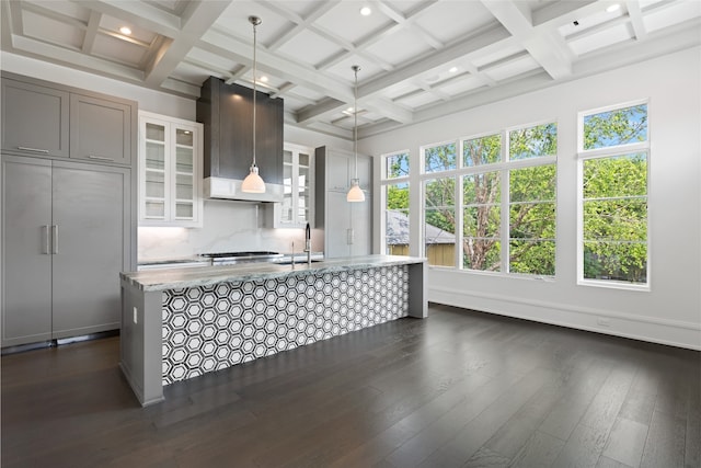 kitchen with a sink, wall chimney exhaust hood, and coffered ceiling