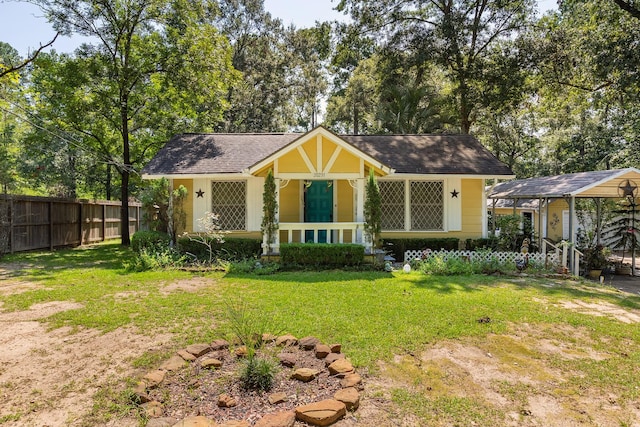 view of front of property featuring fence, a porch, a shingled roof, and a front lawn