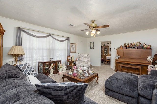living room with visible vents, a ceiling fan, and carpet flooring