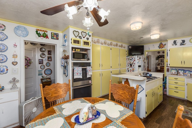 kitchen with yellow cabinetry, appliances with stainless steel finishes, a textured ceiling, and light countertops